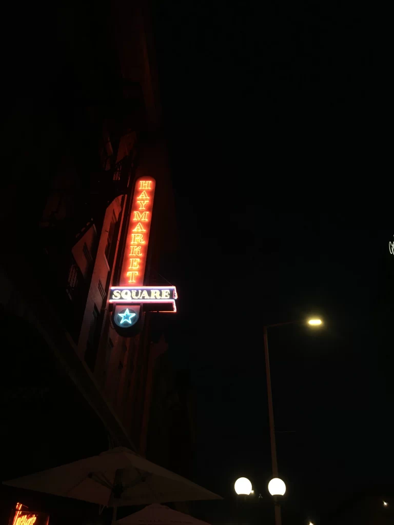 photo of neon lights at night with the words "Haymarket Square"