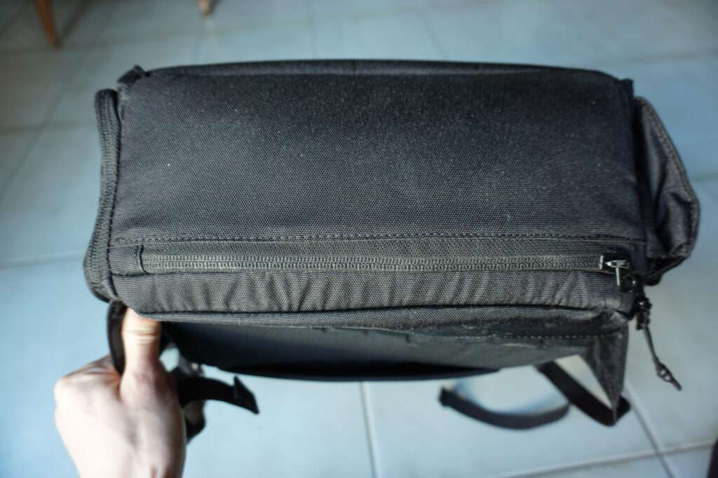 bottom view of black backpack showing kangaroo zipper