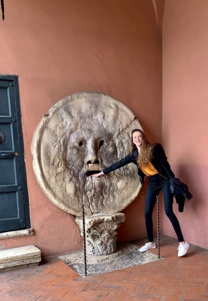 woman placing her hand on a giant marble circular statue