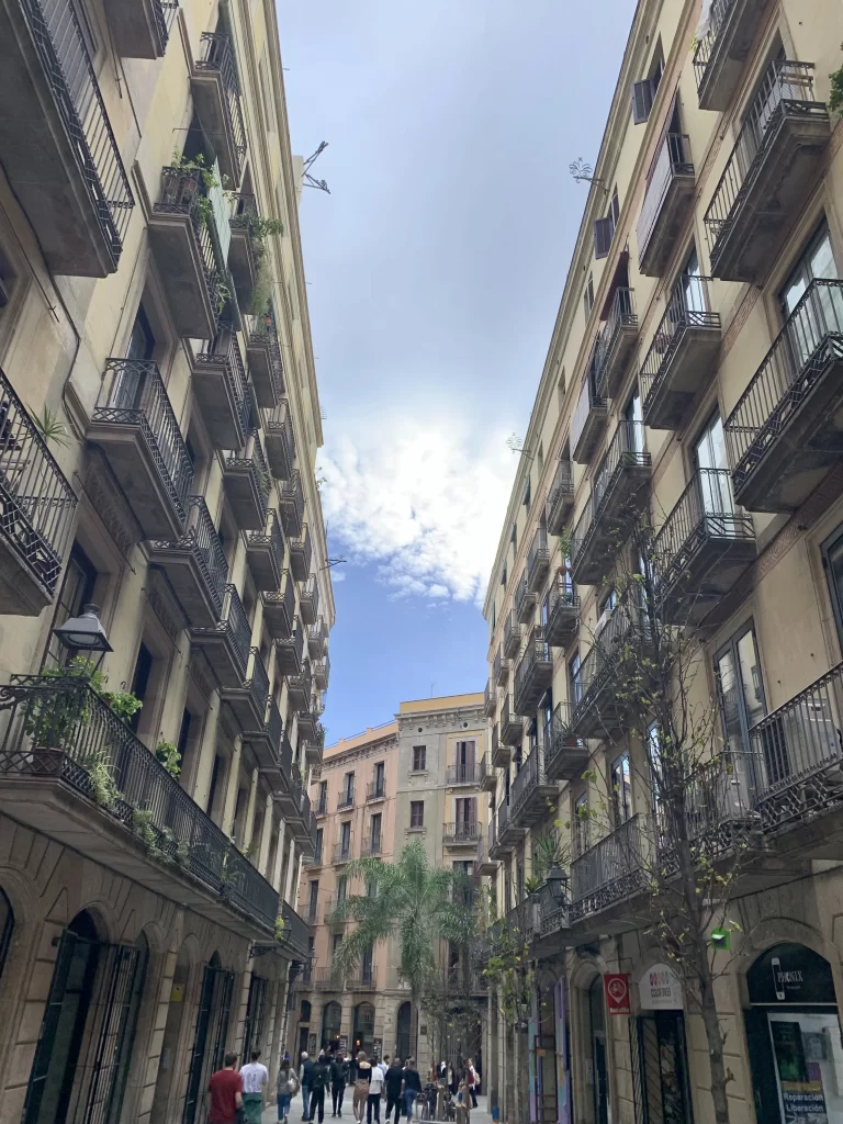 photo of apartment buildings in Barcelona with a blue and cloudy sky in the background