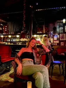 woman sitting in a chair in a dimly-lit bar